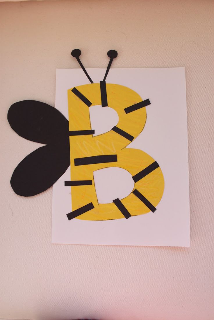 the letter b is made out of construction paper and has a bee on it's side