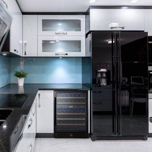 a black and white kitchen with an icebox