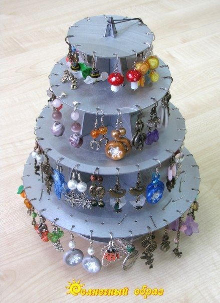 a three tiered jewelry rack with earrings on it