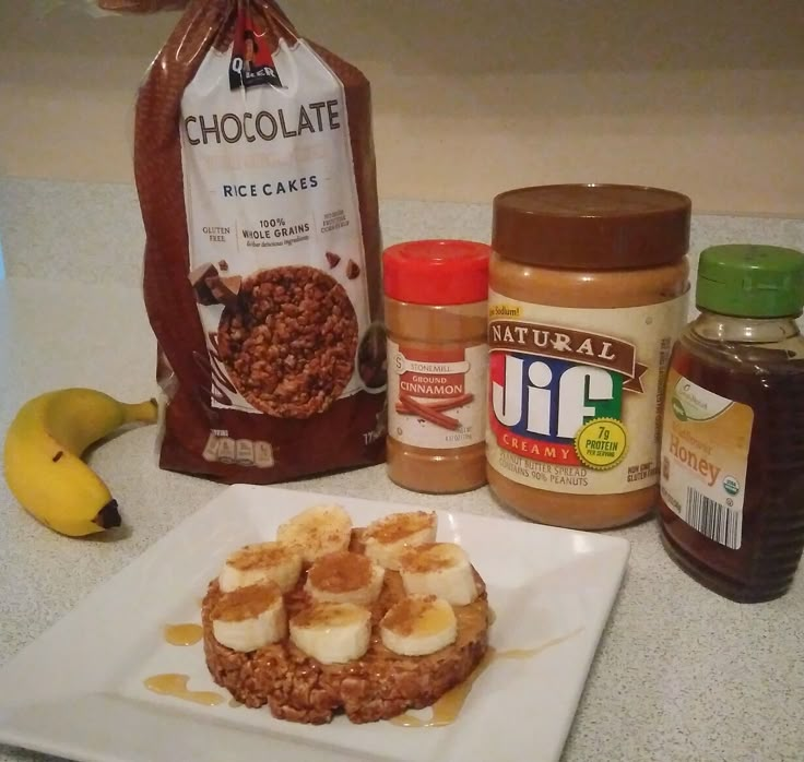 some food is sitting on a white plate with peanut butter and other ingredients next to it