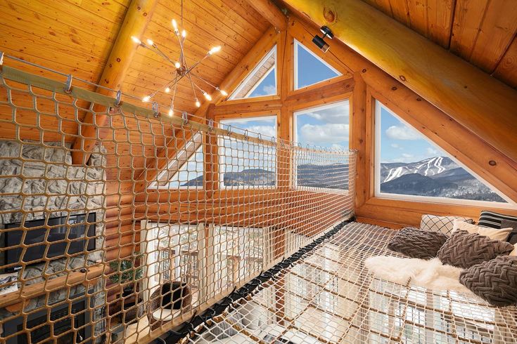 a bedroom with a hammock in the middle of it and a window overlooking mountains