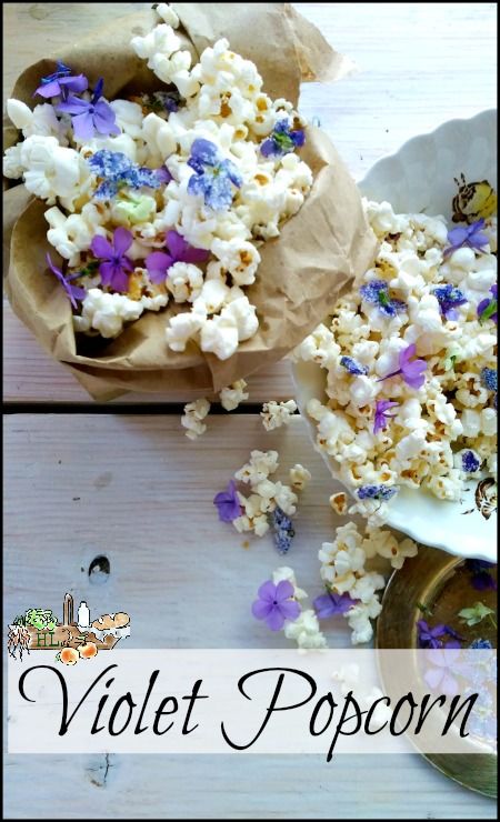 the popcorn is sitting on the table with purple and white flowers