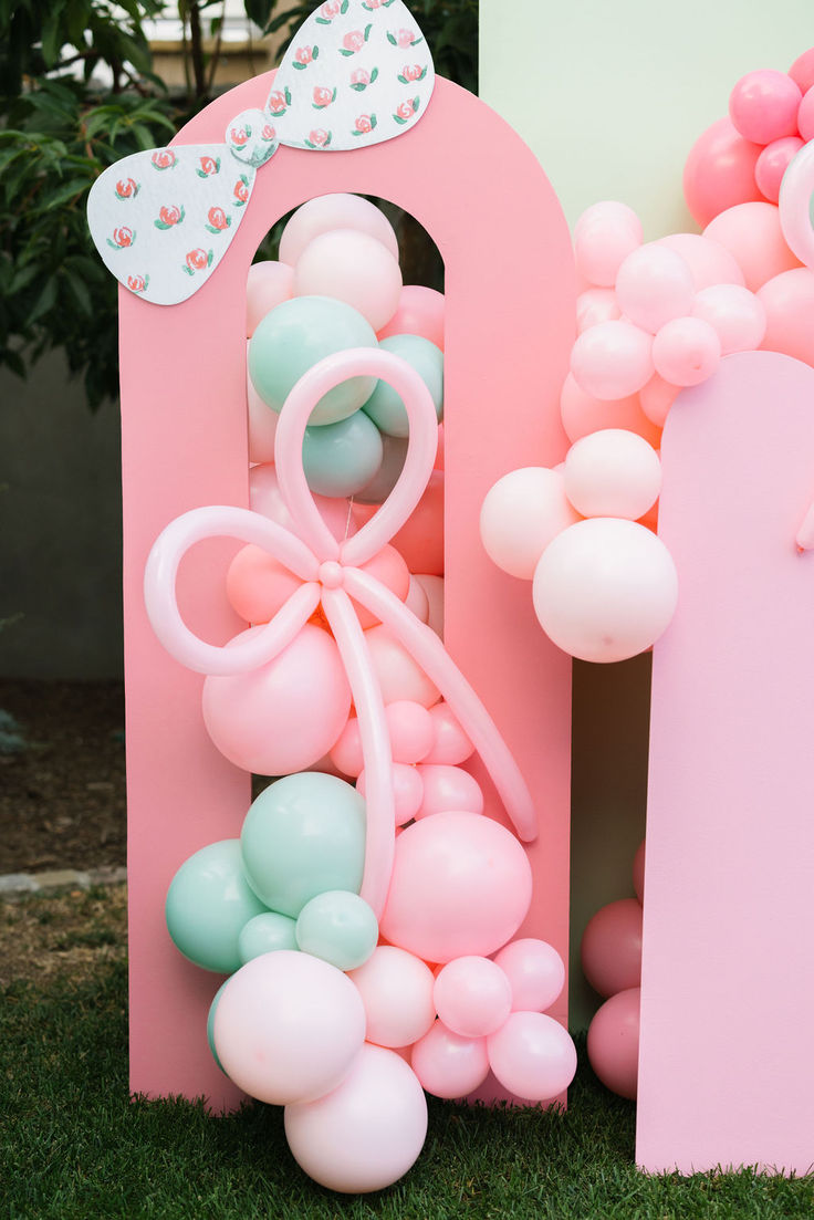 balloons are in the shape of letters and bows on top of each letter, with a bow at the top