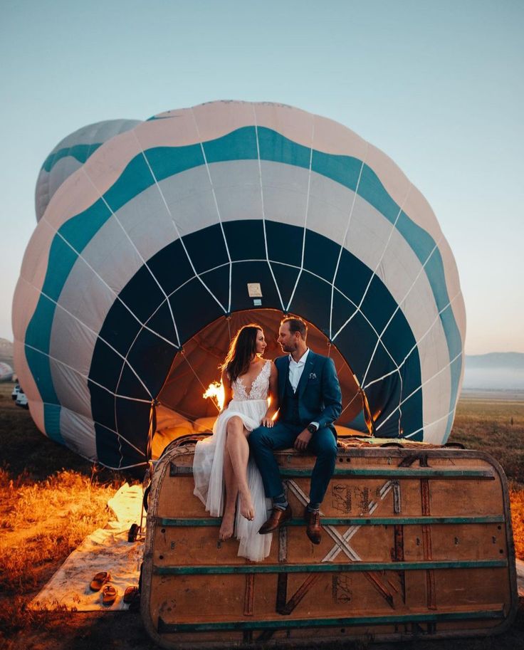 a man and woman sitting on top of a hot air balloon