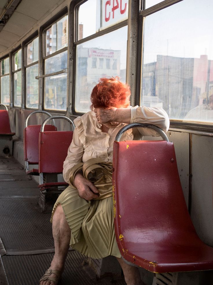 a woman with red hair sitting on a bus