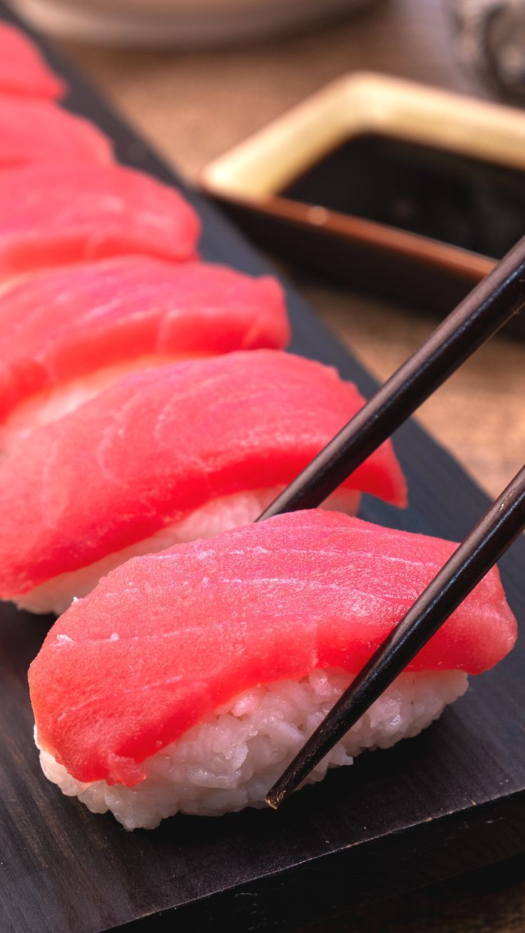 sushi with chopsticks on a black plate