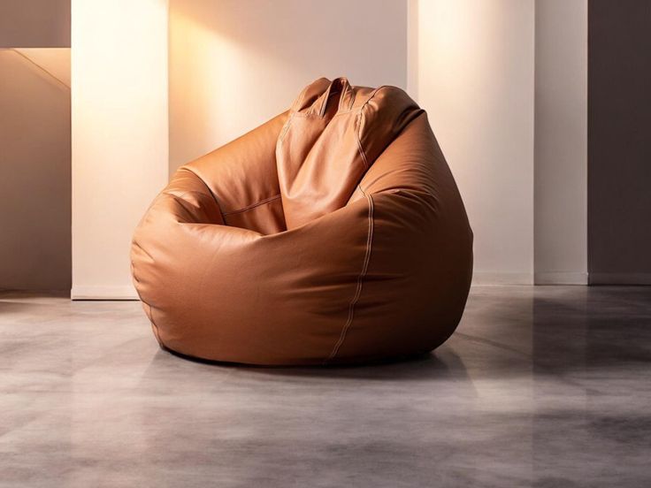 a brown bean bag chair sitting on top of a cement floor next to a lamp