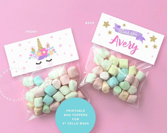 two bags filled with marshmallows sitting on top of a pink table next to each other