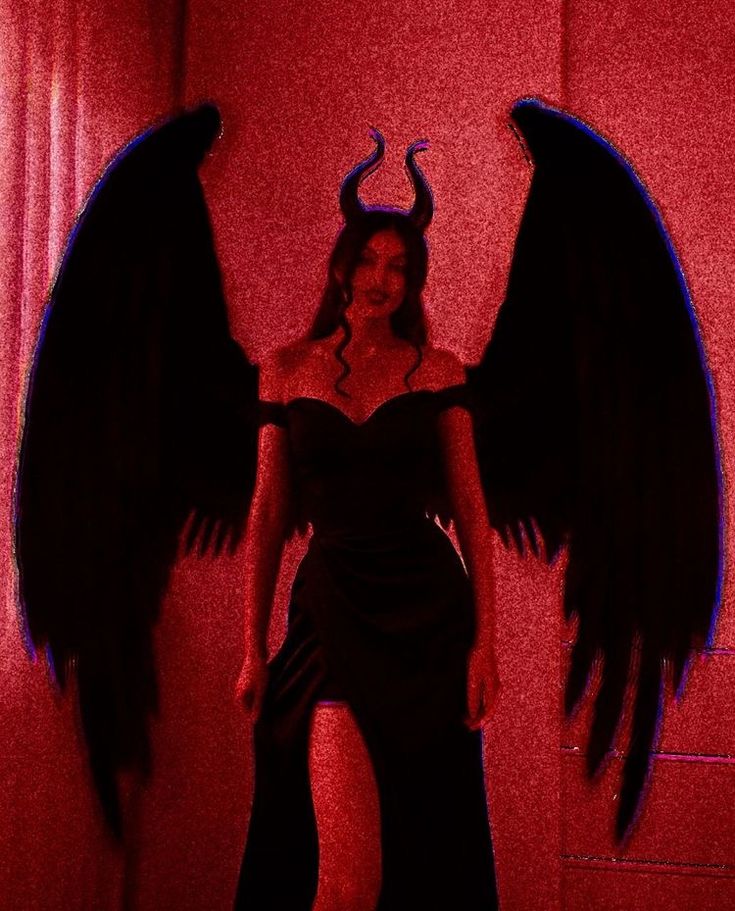 a woman in a black dress with large wings on her head and one wing extended