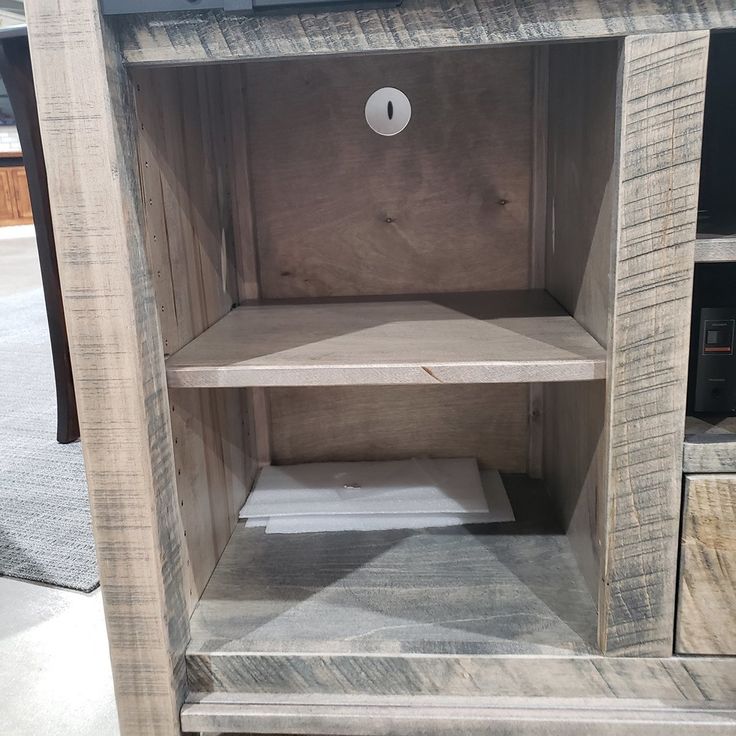 a wooden shelf sitting on top of a carpeted floor