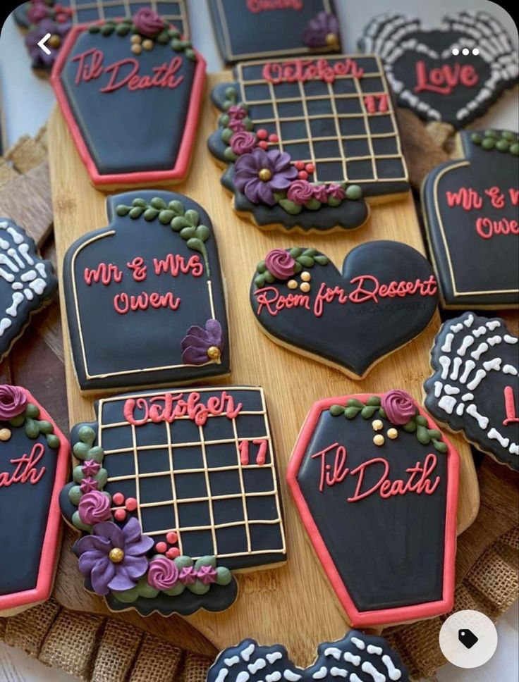 decorated cookies are arranged on a wooden platter