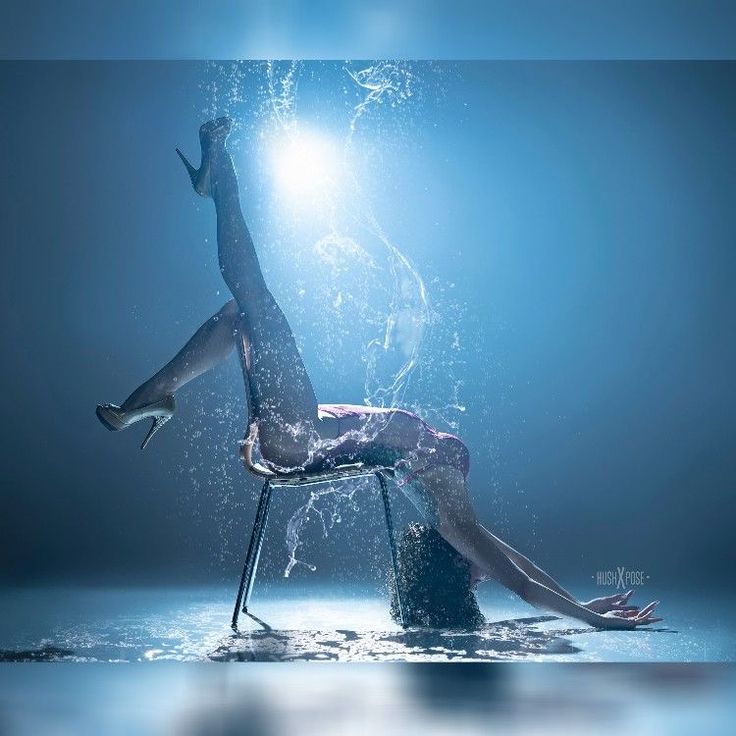 a woman is sitting on a chair in the water and splashing with her legs