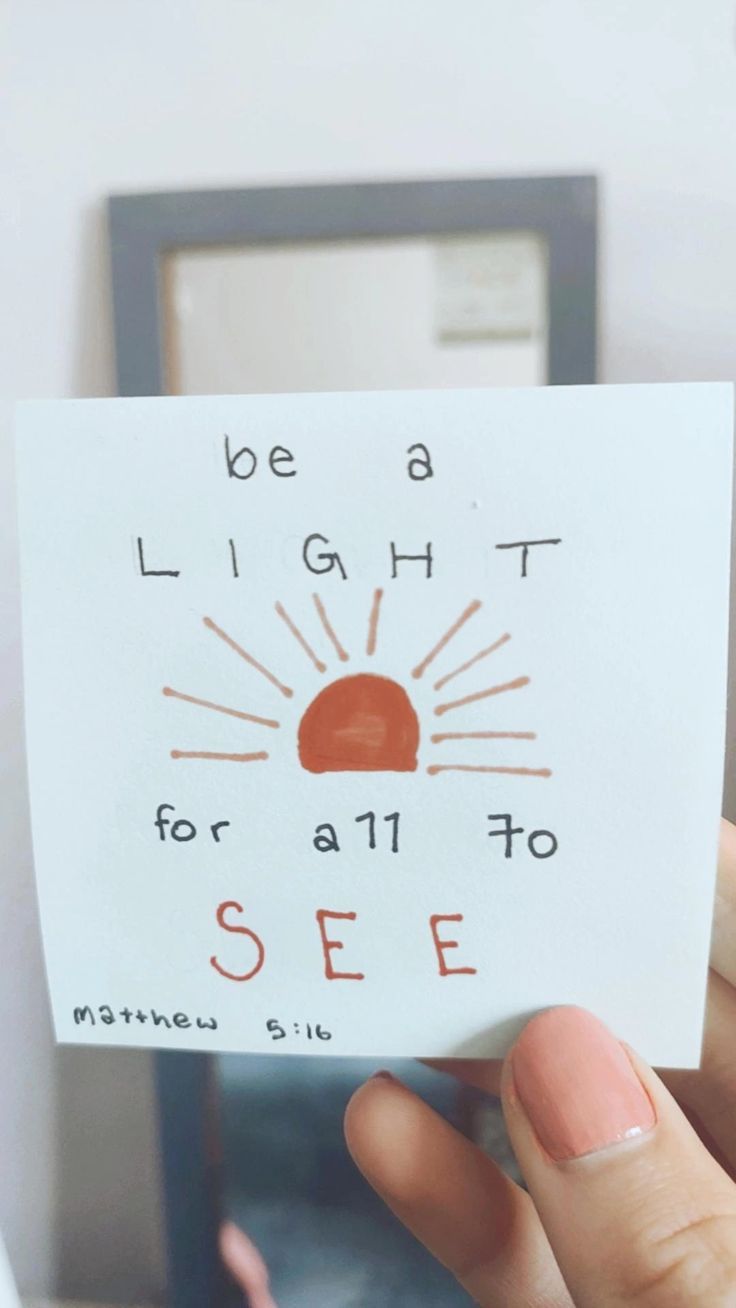 someone holding up a piece of paper that says be a light for all to see