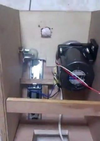 a small room with a toilet and some electrical equipment in the corner on the floor