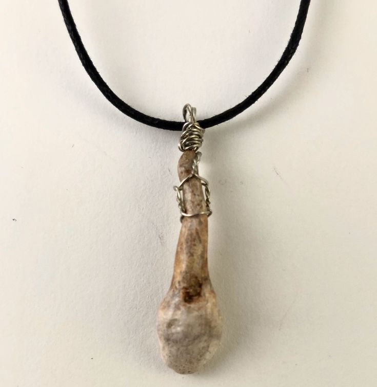 a necklace with a rock hanging from it's side