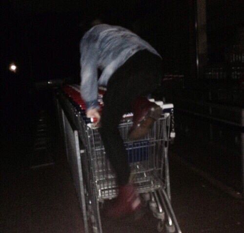 a person pushing a shopping cart in the dark