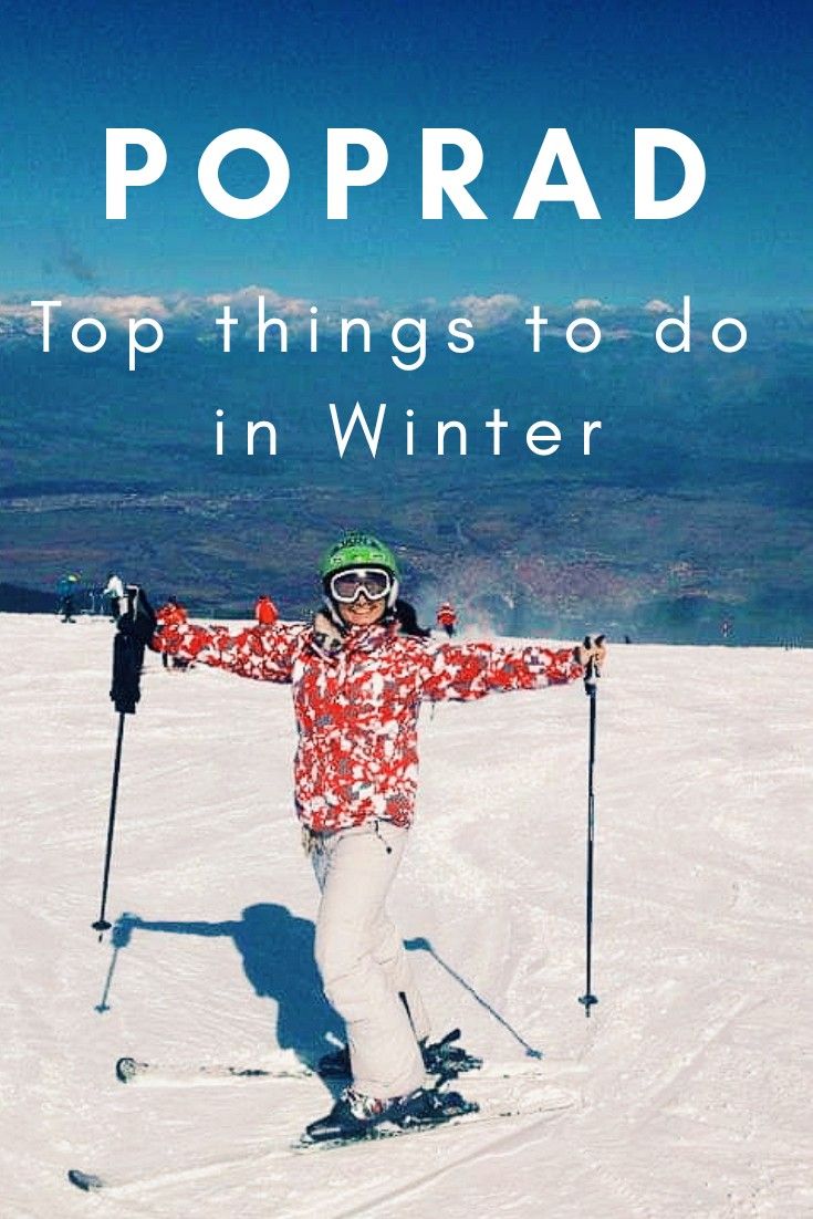 a person on skis standing in the snow with their arms spread out and smiling