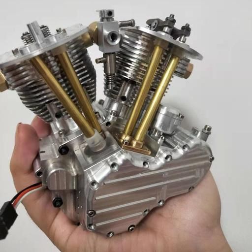 someone is holding three small metal engines in their hand