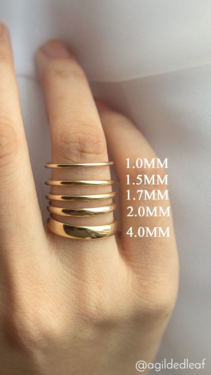 a person's hand with four gold rings on top of their fingers and measurements for each ring