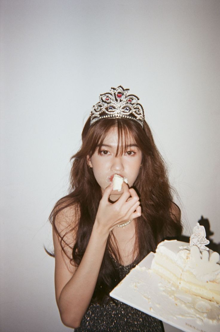 a woman in a tiara eating cake