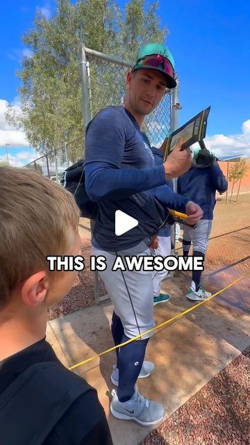 a man holding a baseball bat standing next to a little boy