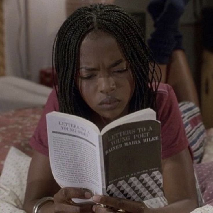 a woman laying in bed reading a book