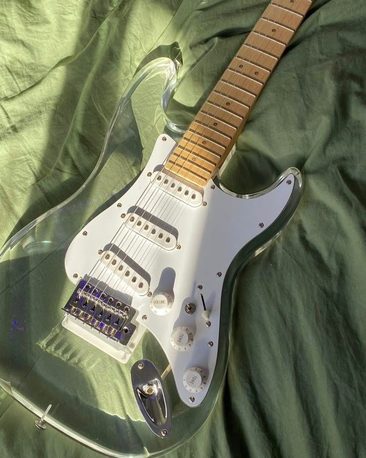 an electric guitar laying on top of a green sheet