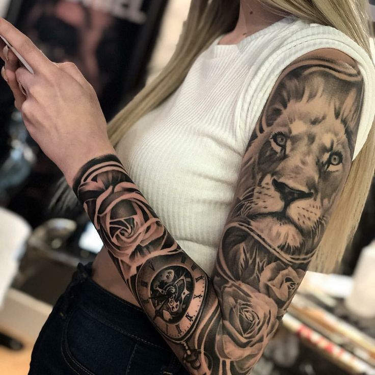 a woman with a lion tattoo on her arm holding a cell phone in her hand