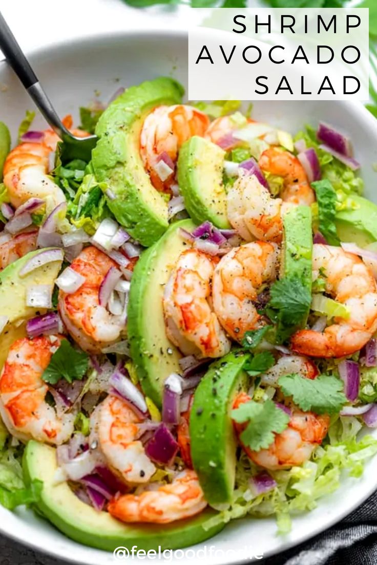 a glass bowl filled with shrimp, cucumber and tomato salad next to an orange slice