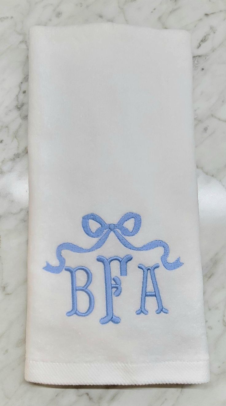 an embroidered monogrammed towel with the letter bfa on it sits on a marble surface