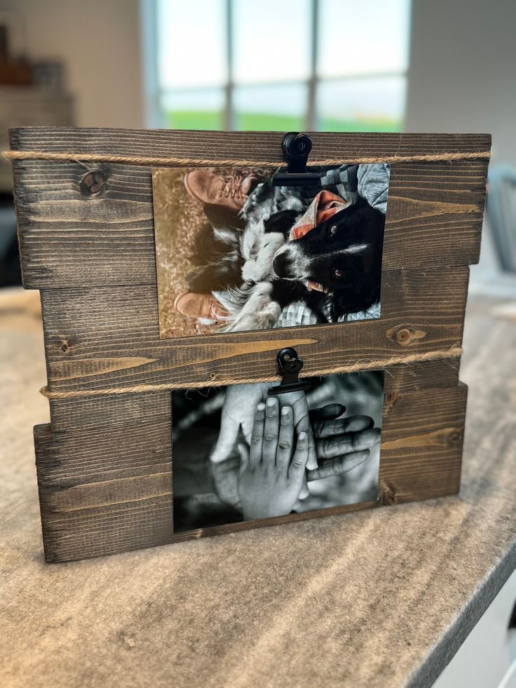 a wooden frame with two pictures hanging from it's sides on top of a counter