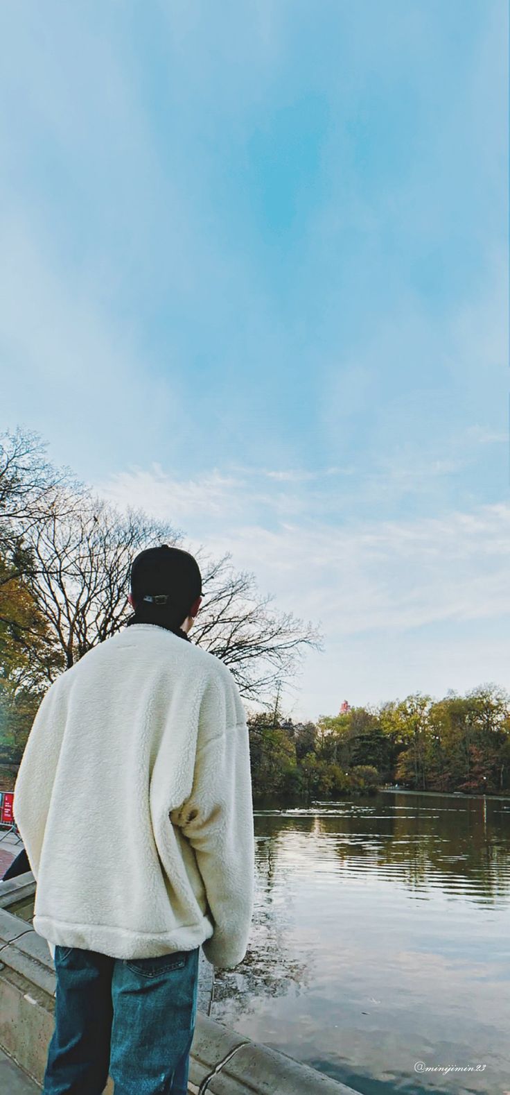 a man standing next to a body of water