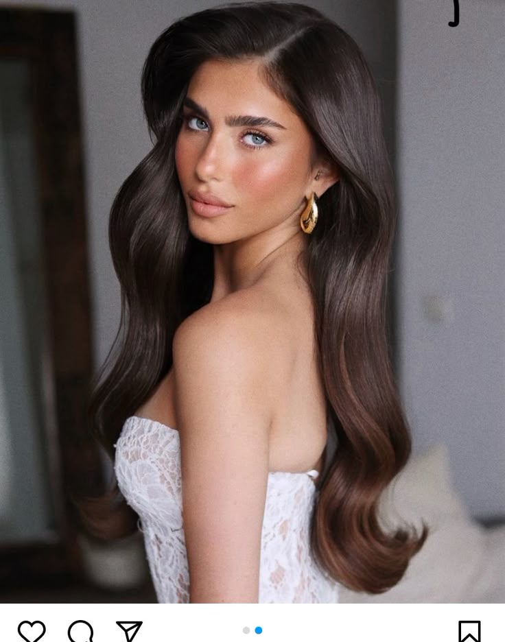 a woman with long brown hair is posing for the camera