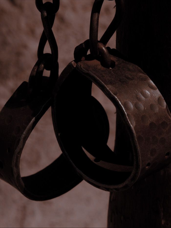 an old pair of handcuffs hanging from a chain