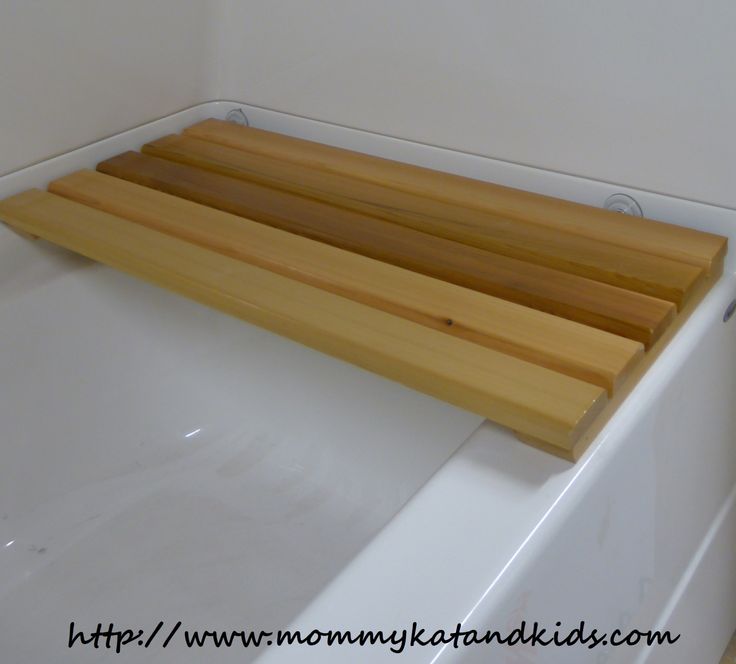 a wooden shelf sitting on top of a white bath tub