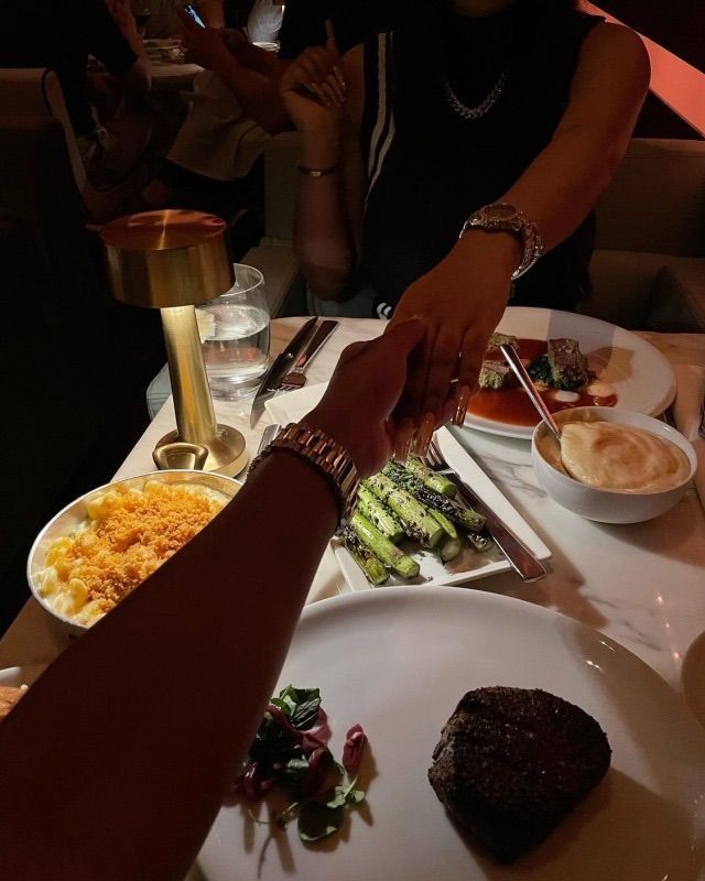 people sitting at a table with plates of food