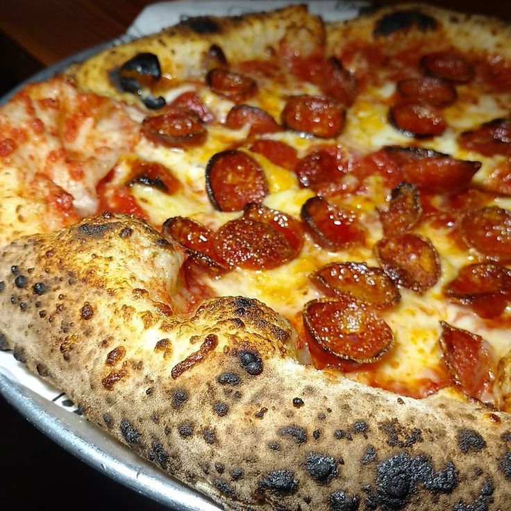 a pepperoni and cheese pizza sitting on top of a pan