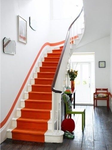 an orange and white stair case in a house