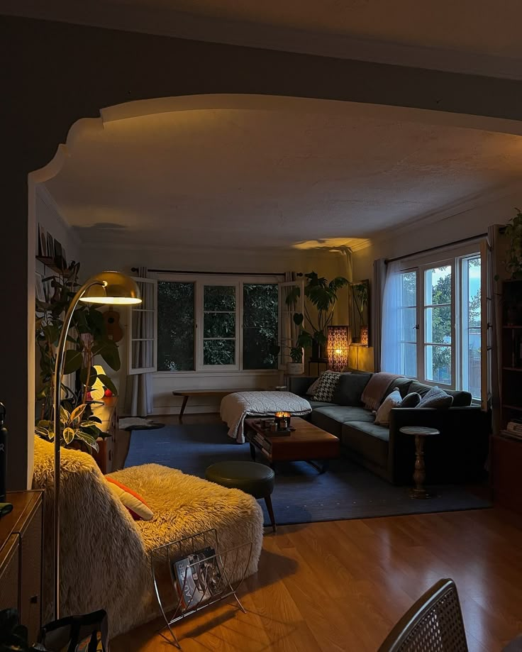 a living room filled with furniture and lots of windows next to a wooden floored floor