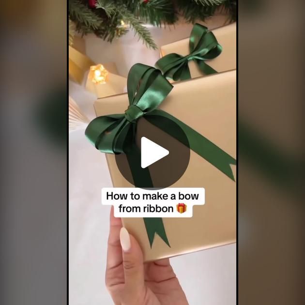 someone is holding a gift wrapped in brown paper with green ribbon and bow on it