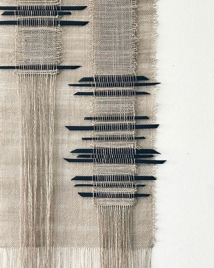 the wall hanging is made with black and white thread, which has fringes on it