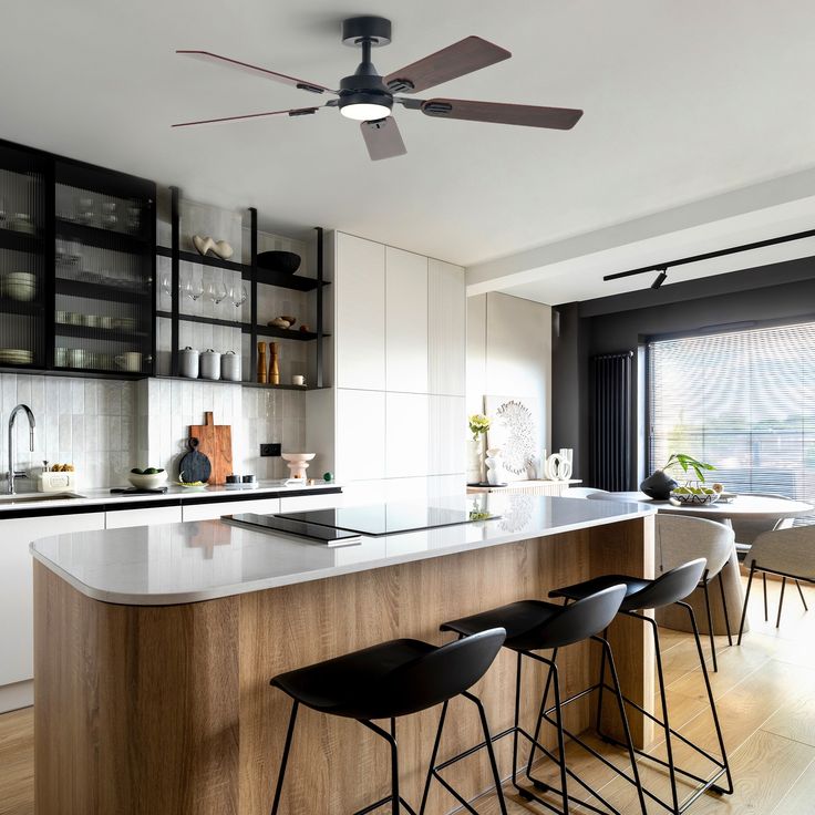 a modern kitchen with an island and bar stools