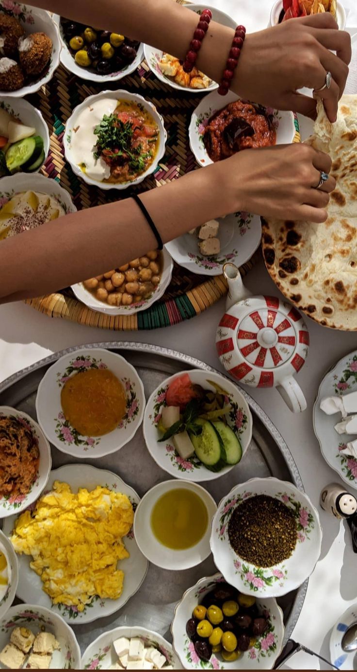 people are serving themselves food at a table