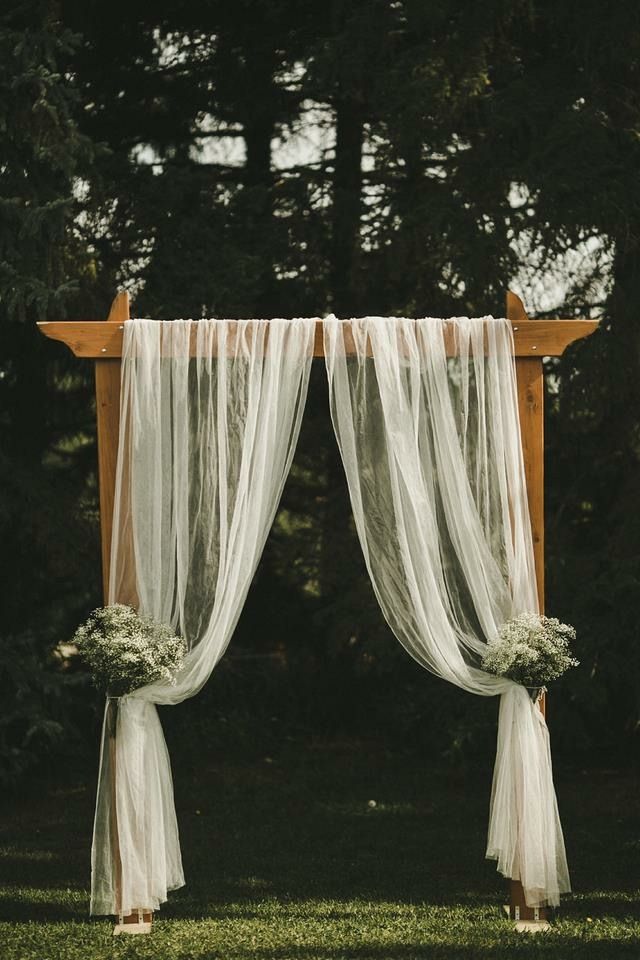 an outdoor ceremony with sheer drapes and flowers