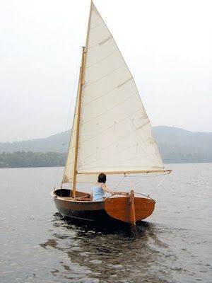 a man in a small sailboat on the water