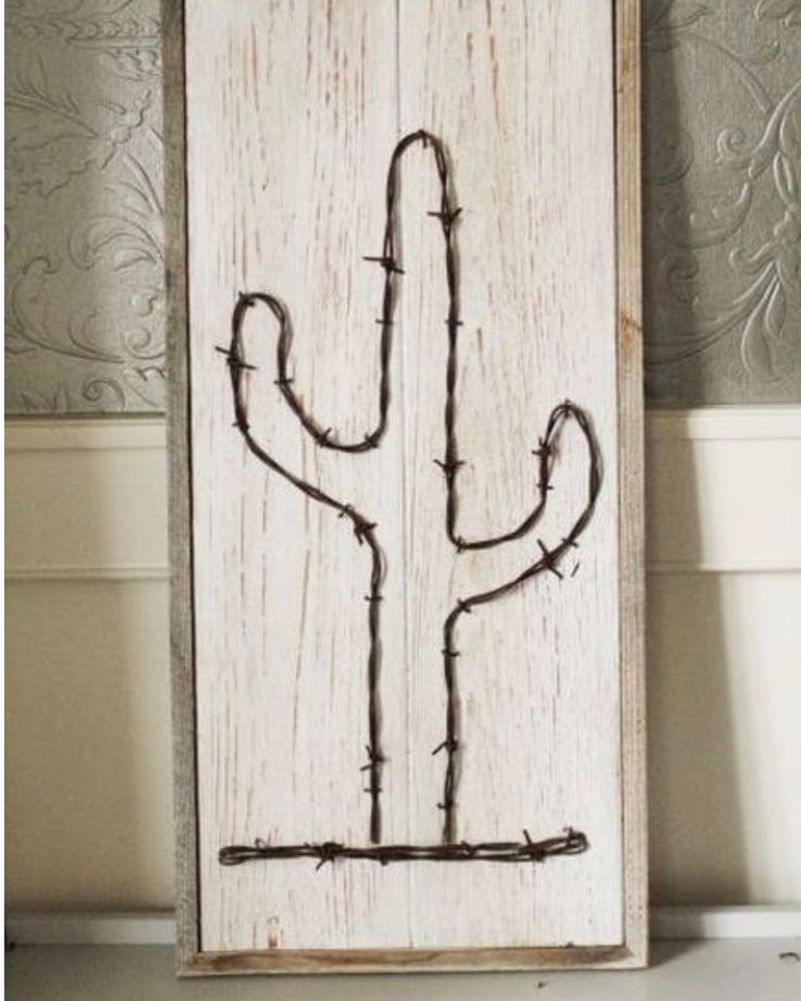 a wooden sign with barbed wire in the shape of a cactus