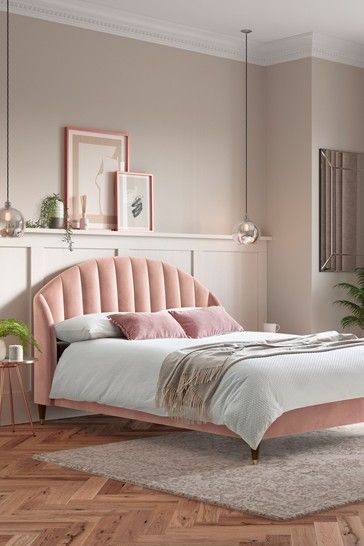 a bedroom with pink walls and wooden floors