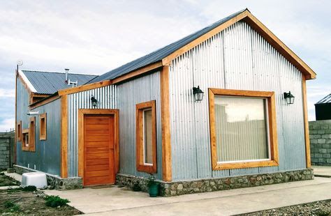 a small metal building with two doors and windows