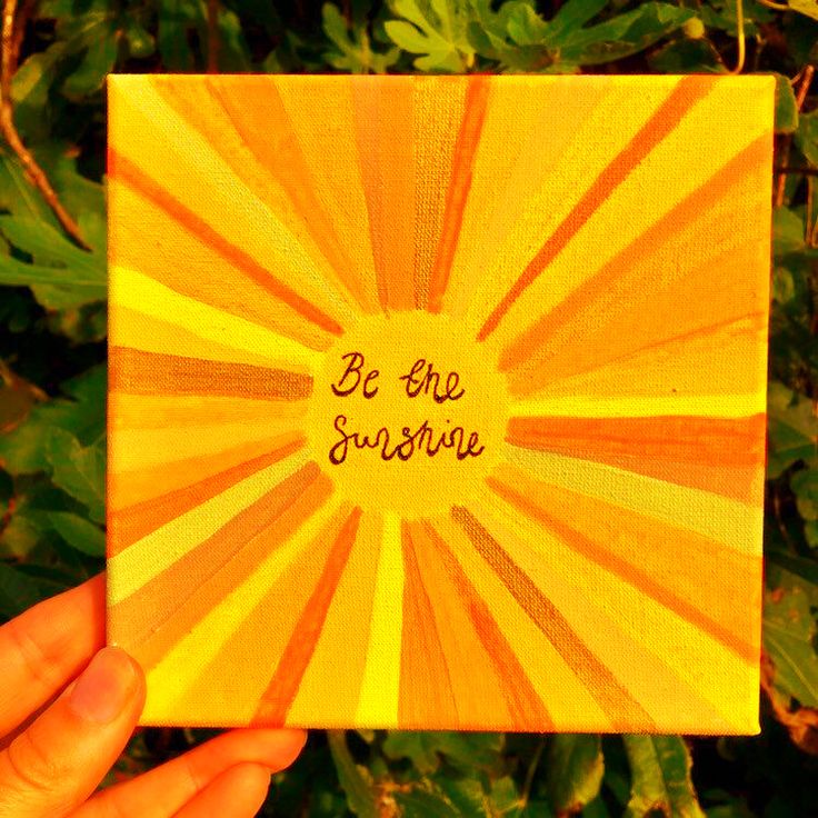 a person holding up a card with the words be the sunshine on it in front of some plants