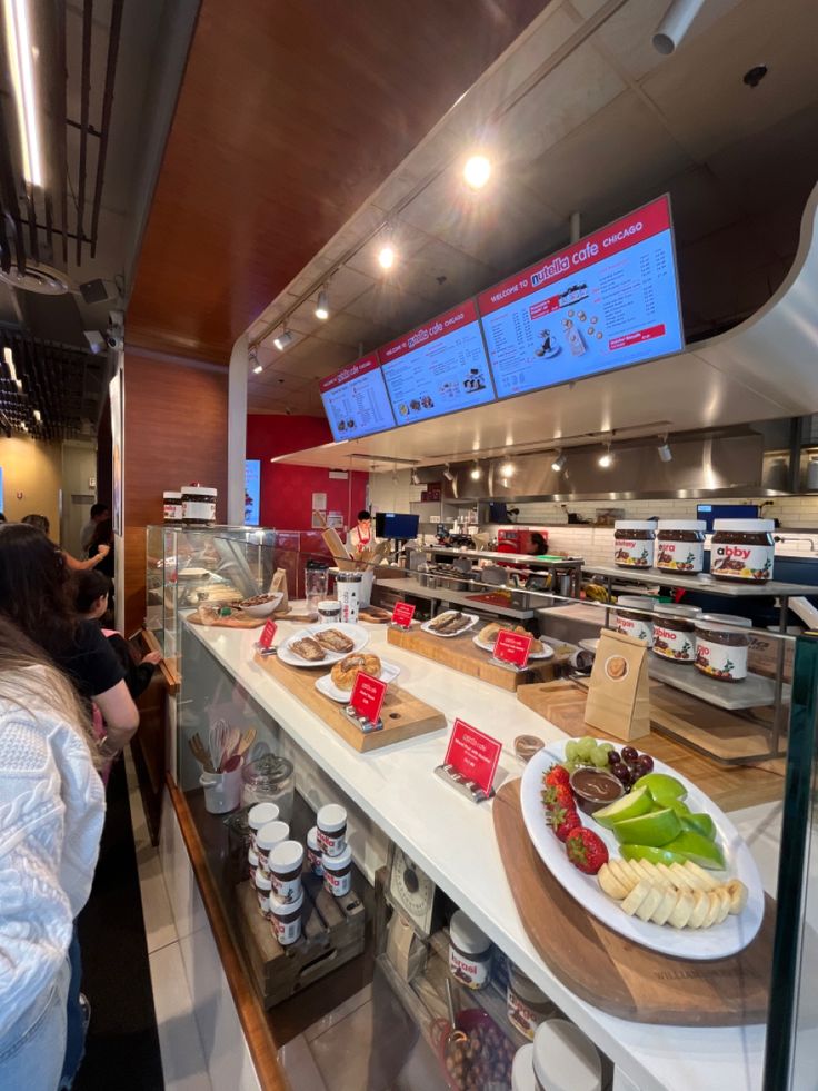 people are standing in line to get food from the counter at a fast food restaurant